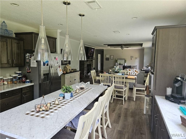 930 Pine Tree Rd, Centreville, AL 35042 - kitchen featuring stainless steel fridge, dark wood-type flooring, a breakfast bar, a fireplace, and ceiling fan