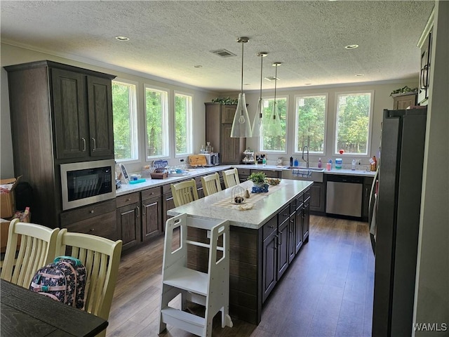 930 Pine Tree Rd, Centreville, AL 35042 - kitchen with stainless steel appliances, wood finished floors, a textured ceiling, open shelves, and crown molding