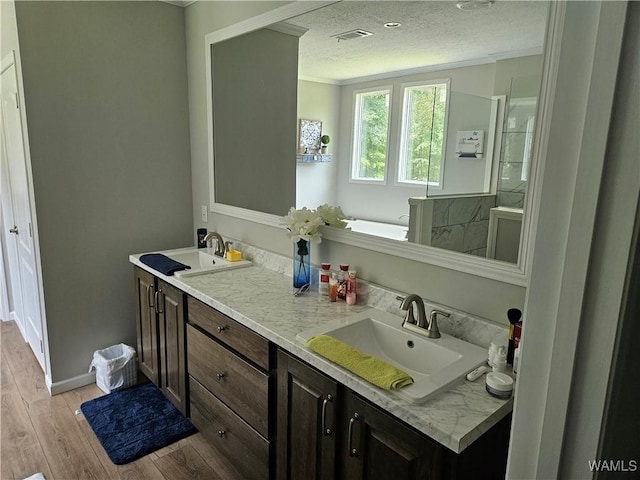 930 Pine Tree Rd, Centreville, AL 35042 - bathroom with double vanity, wood finished floors, crown molding, a textured ceiling, and a garden tub