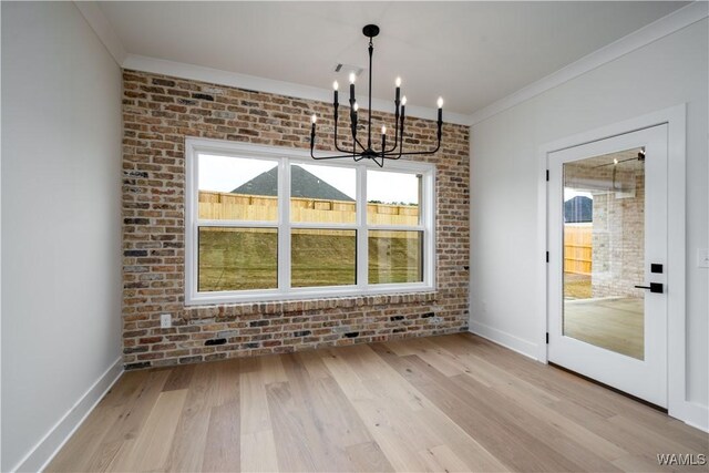 13947 Glenview Dr, Northport, AL 35475 - unfurnished dining area with light wood-style floors, crown molding, and brick wall