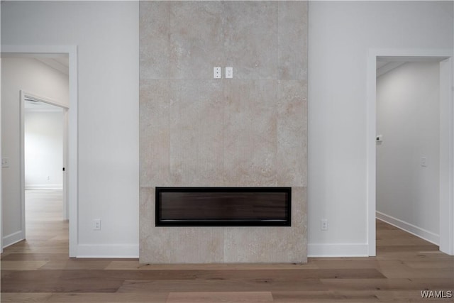 13947 Glenview Dr, Northport, AL 35475 - interior details featuring a glass covered fireplace, baseboards, and wood finished floors