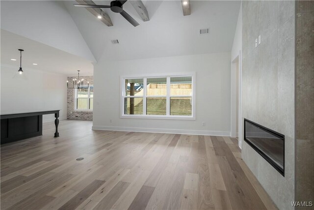 13947 Glenview Dr, Northport, AL 35475 - unfurnished living room with high vaulted ceiling, a large fireplace, ceiling fan with notable chandelier, visible vents, and light wood-style floors