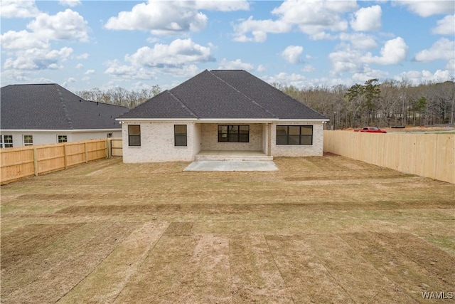 13947 Glenview Dr, Northport, AL 35475 - back of property featuring a lawn, a shingled roof, a fenced backyard, and a patio area