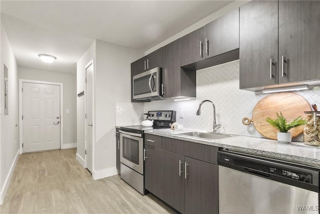 680 6th Ave NE Unit 3310, Tuscaloosa, AL 35404 - kitchen with stainless steel appliances, a sink, backsplash, light wood finished floors, and light countertops