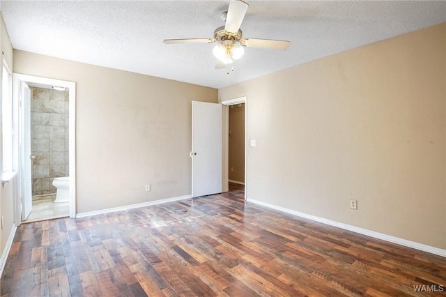 unfurnished bedroom featuring ensuite bathroom, dark hardwood / wood-style floors, and a textured ceiling