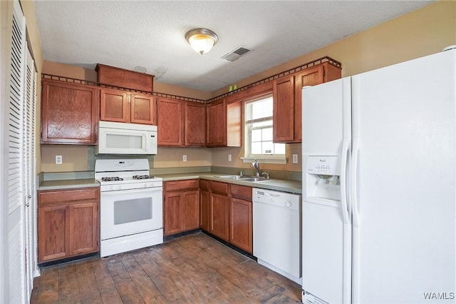 kitchen featuring sink, white appliances, dark hardwood / wood-style floors, and a textured ceiling