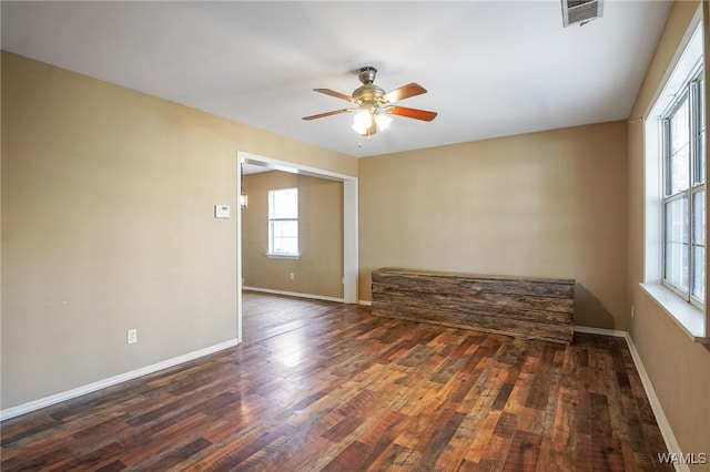 empty room with dark hardwood / wood-style flooring and ceiling fan