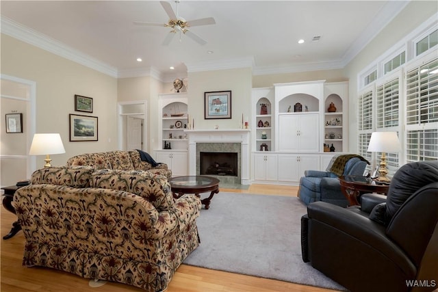 4032 Carousel Cir, Tuscaloosa, AL 35406 - living area with light wood finished floors, a ceiling fan, crown molding, a fireplace with flush hearth, and built in features
