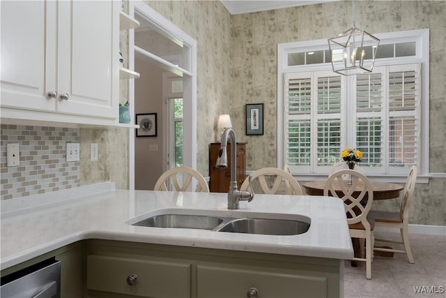 4032 Carousel Cir, Tuscaloosa, AL 35406 - kitchen featuring a chandelier, light countertops, white cabinets, light tile patterned floors, and backsplash