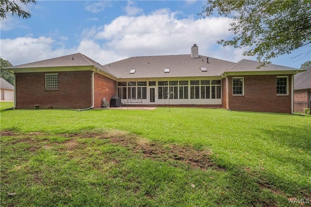 4032 Carousel Cir, Tuscaloosa, AL 35406 - back of house with a chimney, a lawn, a sunroom, and brick siding