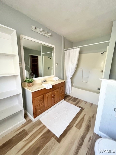 bathroom with wood-type flooring, vanity, and shower / bathtub combination with curtain