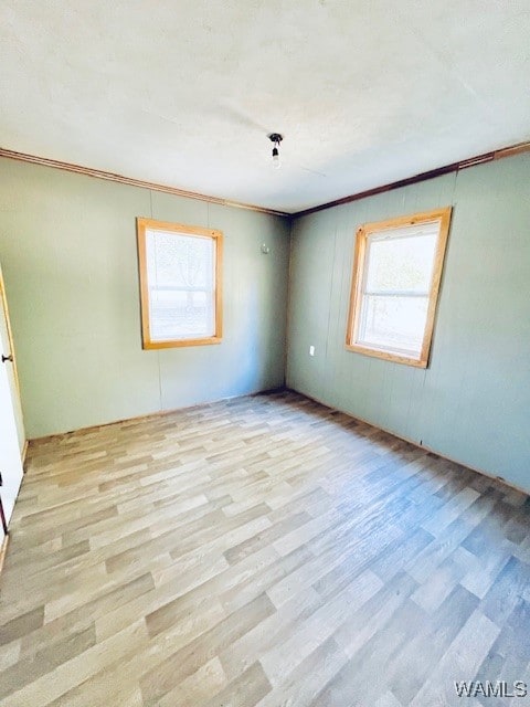 unfurnished room featuring light hardwood / wood-style floors and ornamental molding