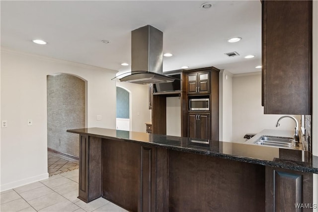 kitchen with island exhaust hood, sink, stainless steel microwave, and kitchen peninsula