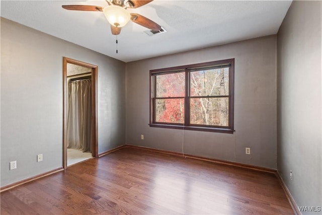 empty room featuring hardwood / wood-style floors and ceiling fan