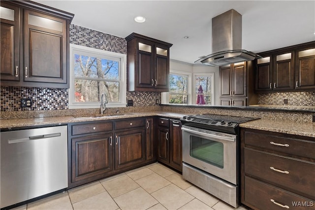 kitchen with appliances with stainless steel finishes, island range hood, sink, decorative backsplash, and dark brown cabinets