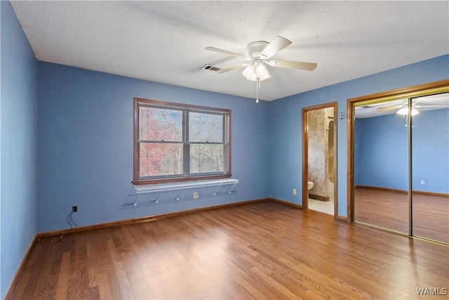 unfurnished bedroom featuring ceiling fan, a textured ceiling, light hardwood / wood-style floors, and a closet