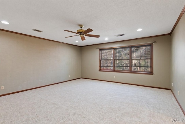 carpeted empty room featuring crown molding, ceiling fan, and a textured ceiling