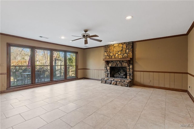 unfurnished living room with crown molding, light tile patterned floors, a stone fireplace, and ceiling fan