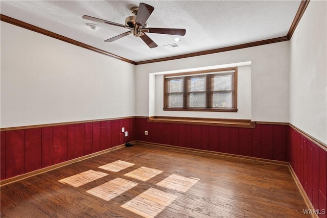 unfurnished room featuring ceiling fan, wood-type flooring, ornamental molding, and a textured ceiling