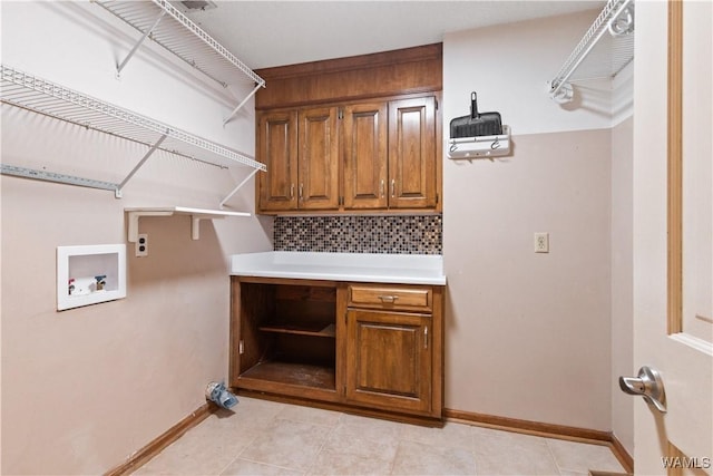 washroom featuring cabinets, washer hookup, light tile patterned floors, and electric dryer hookup