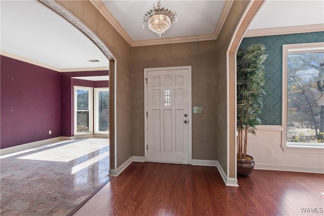 entrance foyer featuring ornamental molding, dark wood-type flooring, and a chandelier