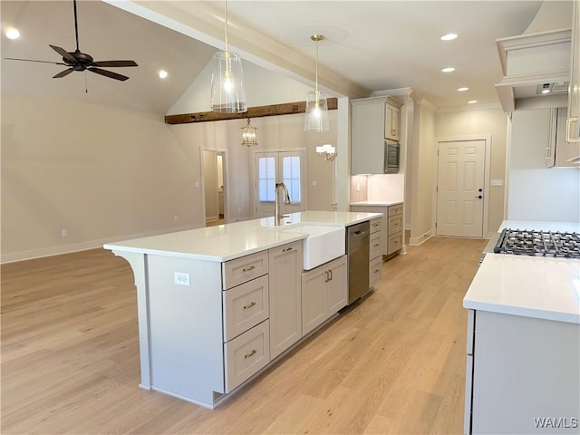 kitchen with ceiling fan with notable chandelier, a spacious island, appliances with stainless steel finishes, sink, and hanging light fixtures