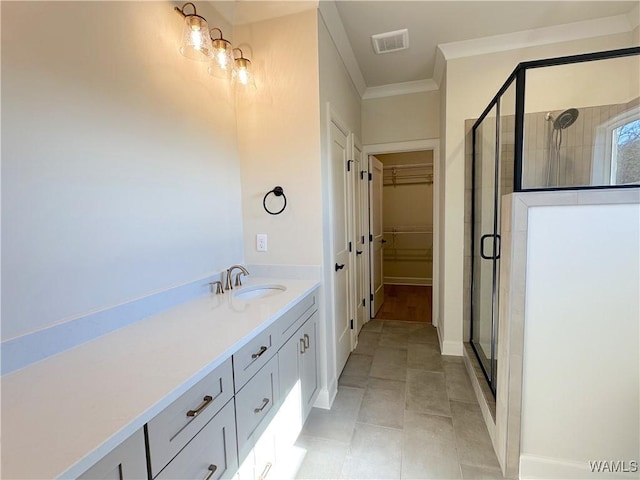 bathroom featuring tile patterned flooring, a shower with door, crown molding, and vanity