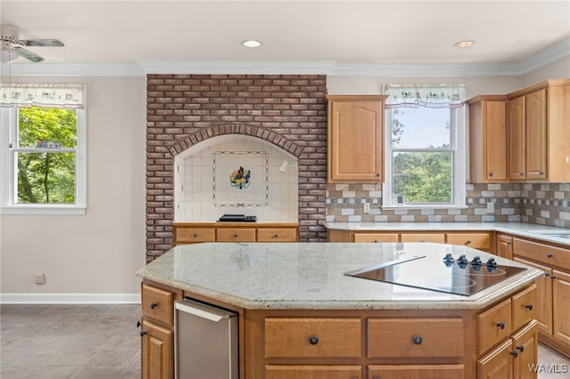 4184 Graves Gap Rd, Hayden, AL 35079 - kitchen with black electric cooktop, a center island, decorative backsplash, a ceiling fan, and light stone counters