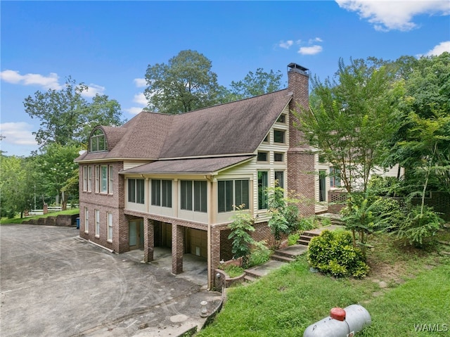 4184 Graves Gap Rd, Hayden, AL 35079 - back of house with driveway, an attached garage, a chimney, and brick siding