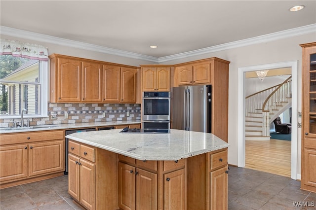 4184 Graves Gap Rd, Hayden, AL 35079 - kitchen featuring appliances with stainless steel finishes, backsplash, light stone counters, a center island, and ornamental molding