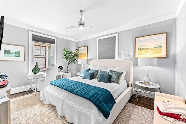 bedroom with a ceiling fan, ornamental molding, baseboards, and wood finished floors