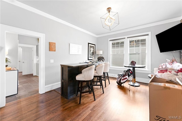 interior space with baseboards, wood finished floors, and crown molding