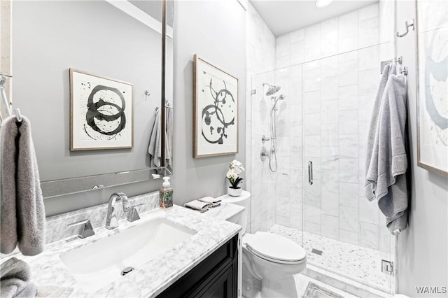 bathroom with a stall shower, vanity, and toilet