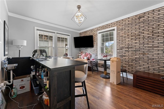 office with brick wall, ornamental molding, and wood finished floors