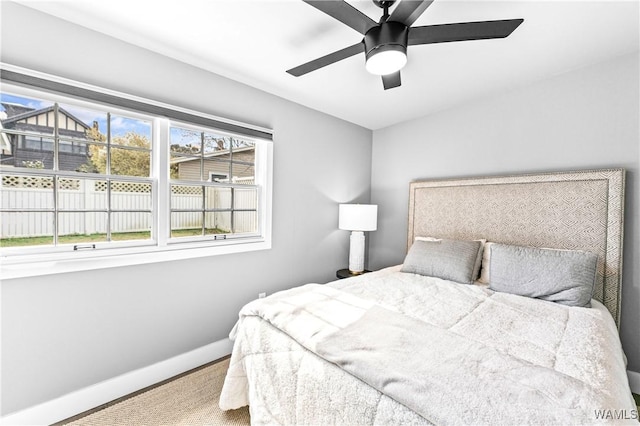 bedroom with a ceiling fan and baseboards