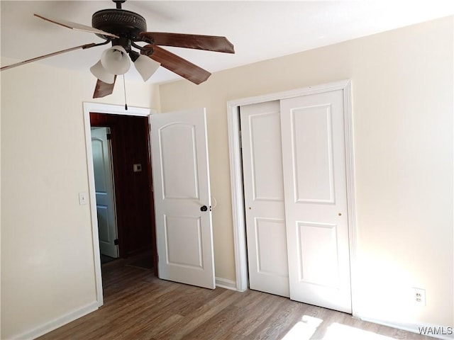 2205 18th Ave, Northport, AL 35476 - unfurnished bedroom featuring wood finished floors, a closet, baseboards, and ceiling fan