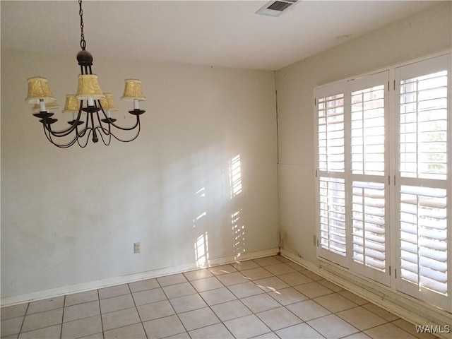 empty room with baseboards, visible vents, a notable chandelier, and light tile patterned flooring