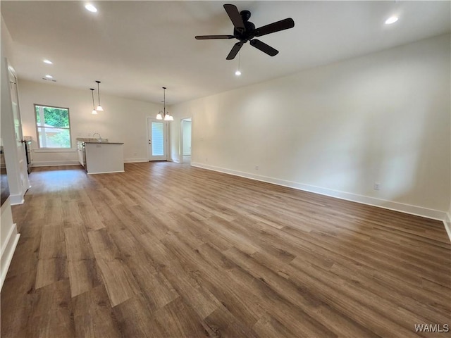 195 Lecroy Cir, Brent, AL 35034 - unfurnished living room with dark wood-style floors, recessed lighting, ceiling fan, baseboards, and a chandelier