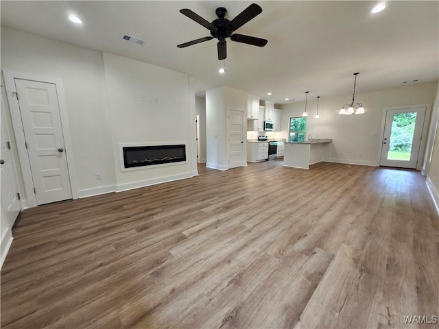 195 Lecroy Cir, Brent, AL 35034 - unfurnished living room featuring a glass covered fireplace, wood finished floors, a ceiling fan, recessed lighting, and baseboards