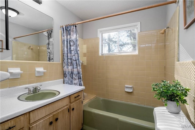 bathroom with tasteful backsplash, shower / bath combo with shower curtain, vanity, and tile walls