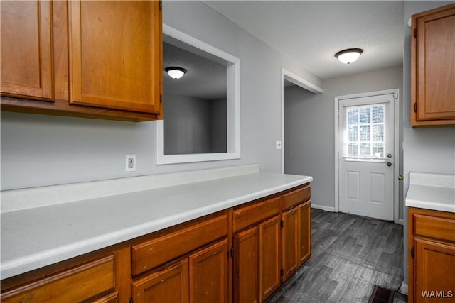 kitchen featuring brown cabinets, light countertops, and dark wood finished floors