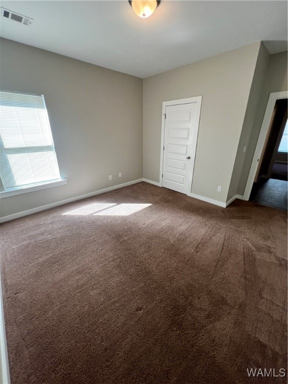 empty room with dark colored carpet