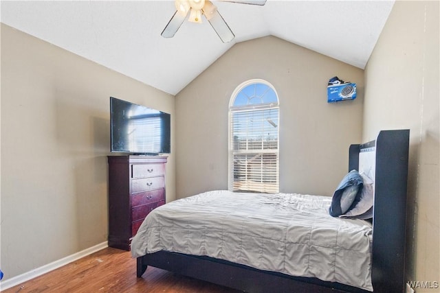 bedroom with a ceiling fan, vaulted ceiling, baseboards, and wood finished floors