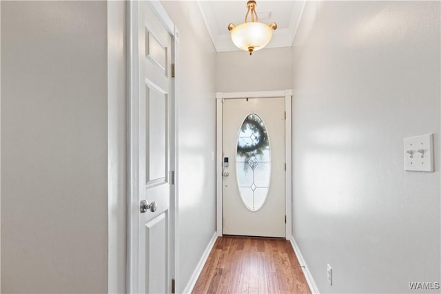 entryway featuring crown molding, light wood-style flooring, and baseboards