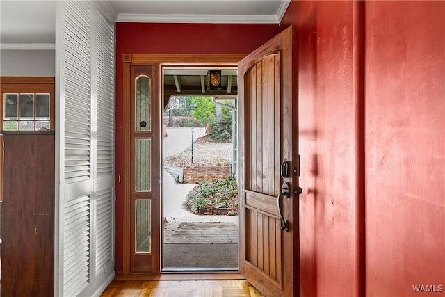 doorway to outside featuring crown molding and light parquet floors