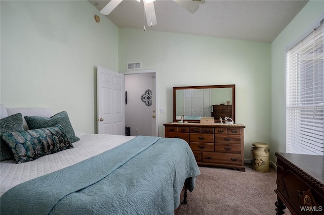 carpeted bedroom featuring lofted ceiling, ceiling fan, and visible vents