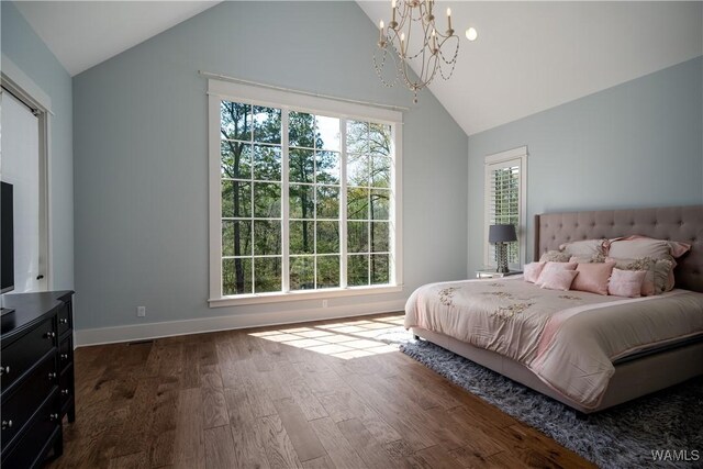 bedroom with dark wood-style floors, a chandelier, lofted ceiling, and baseboards