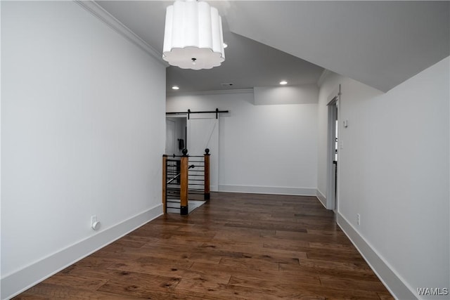 corridor with a barn door, recessed lighting, crown molding, and baseboards