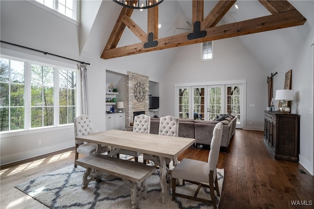 dining room with high vaulted ceiling, a healthy amount of sunlight, and a fireplace