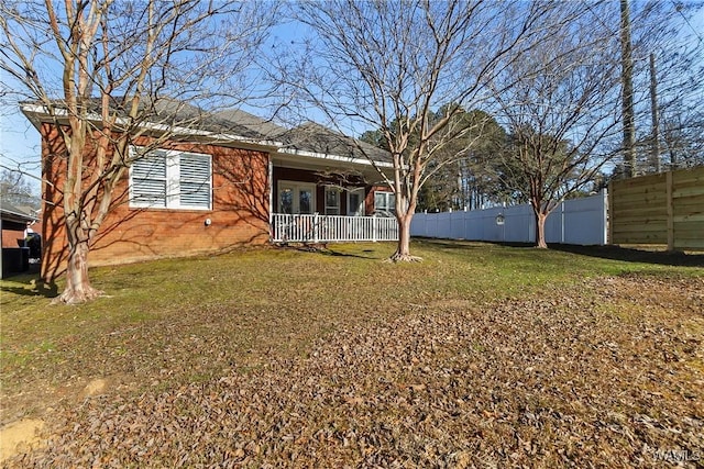 rear view of house with a yard and covered porch